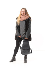 Fototapeta premium A girl in demi-season clothes with a full-length bag on a white background.