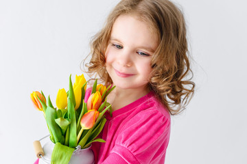 happy baby girl holding a bouquet of yellow tulips. happy mother's Day. international women day.	