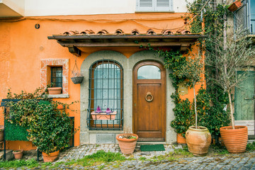 facade of beautiful building with potted plants and flowers in Castel Gandolfo, Rome suburb, Italy