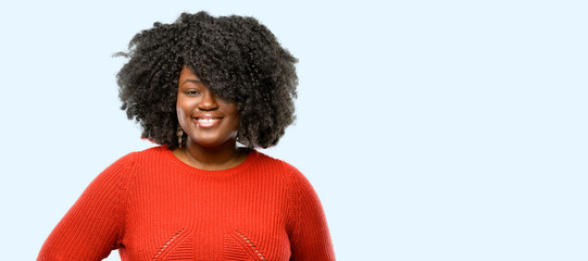 Beautiful african woman confident and happy with a big natural smile laughing, blue background