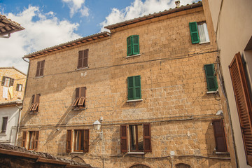 windows with brown and green shutters in Orvieto, Rome suburb, Italy