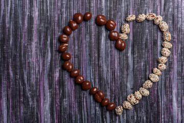 Peanuts in chocolate. Peanut with caramel and sesame seeds. Sweet peanut posted heart.
