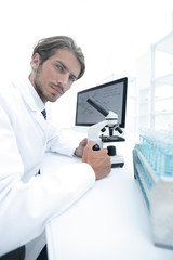 Student in biology using microscope in training class