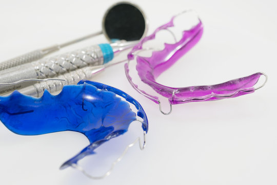 Dental  tools  and retainer orthodontic appliance on the white background.
