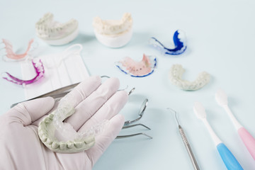 Dental  tools  and retainer orthodontic appliance on the blue background.