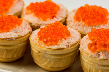 Tartlets with cheese and red caviar. Selective focus. Copy space