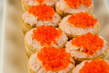 Tartlets with cheese and red caviar. Selective focus. Copy space