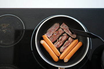 Hotdog and meats on electric stove 
