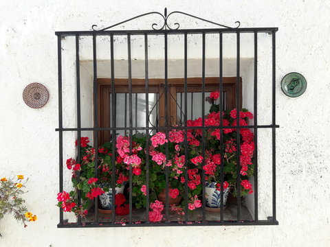 Bonito balcon de pueblos con sus macetas de geranios