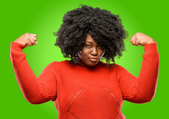 Beautiful african woman showing biceps expressing strength and gym concept, healthy life its good