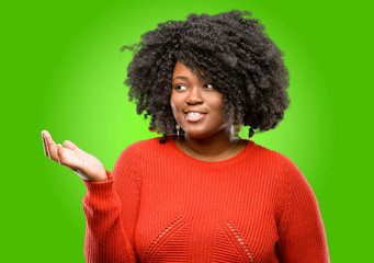 Beautiful african woman holding something in his empty hand