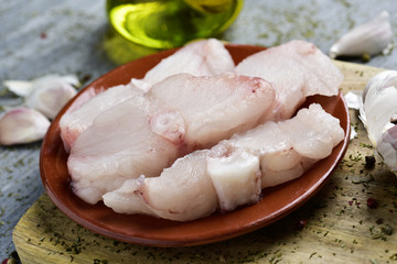 slices of raw monkfish on a rustic table