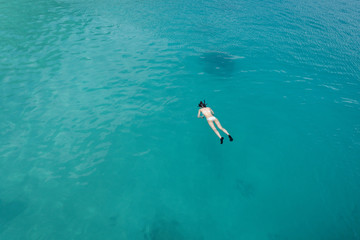 Young woman snorkeling in clear tropical turquoise waters