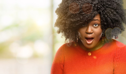 Beautiful african woman scared in shock, expressing panic and fear, outdoor