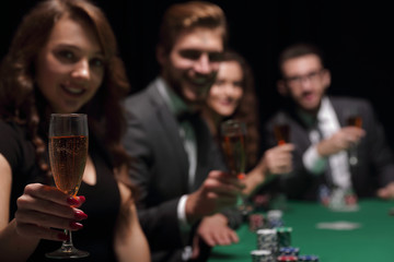 fashion woman with glasses of wine,sitting at a table in a casino