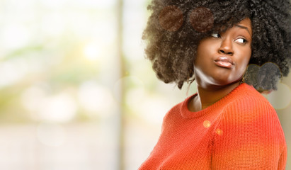 Beautiful african woman doubt expression, confuse and wonder concept, uncertain future, outdoor