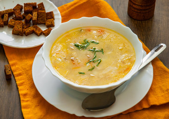 Bowl of chicken soup with vegetables on a wooden background