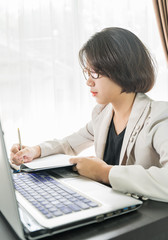 Woman teenage working on laptop in home office