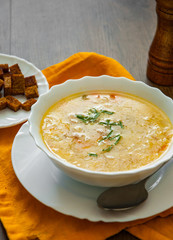 Bowl of chicken soup with vegetables on a wooden background
