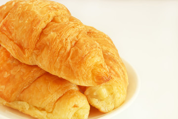 Close up freshly baked croissants on white background with copy space.