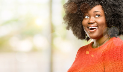 Obraz premium Beautiful african woman happy and surprised cheering expressing wow gesture, outdoor