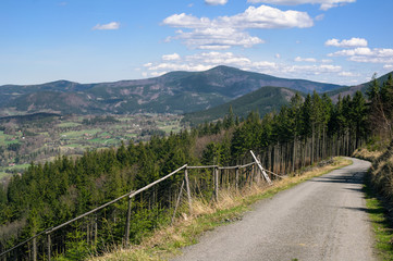 Fototapeta na wymiar View from Mala Stolova, Near Celadna, Beskids ( Beskydy ), Western Carpathians, Czech Republic / Czechia. Road and path for tourists. Lysa hora mountain in the distance.