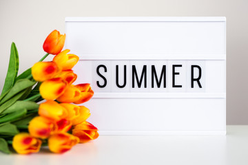 lightbox with word "summer" and flowers on the table