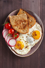 Healthy simple breakfast with bread toast, fried eggs and vegetables