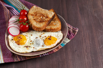 Healthy simple breakfast with bread toast, fried eggs and vegetables