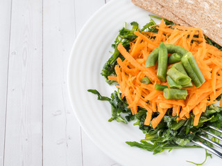 Healthy salad of grated carrots green bean arugula