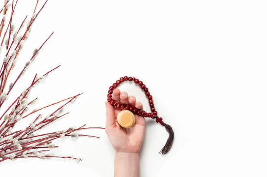 Female hand holding liturgical bread prosfora and rosary beads