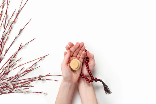 Female hand holding liturgical bread prosfora and rosary beads