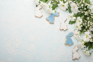 White chrysanthemums on a wooden background, and homemade cookies in the form of bunnies, with an empty space for writing or advertising