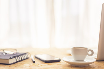 Coffee cup and laptop against the window