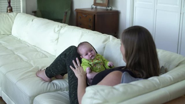 Mother wiping mouth of newborn daughter after sneezing.