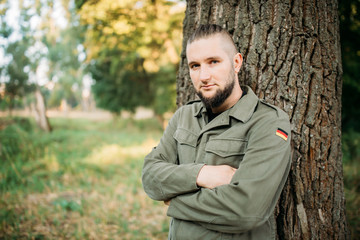 Portrait of a young guy with a beard in nature.