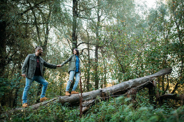 Walk a guy and a girl. Love story in the forest. Youth in nature.