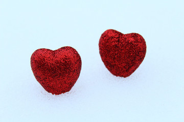 Beautiful red volumetric hearts on white snow. Close-up. Background.