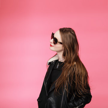fashion model wearing black in sunglasses, beautiful young woman. leather jacket, studio shot