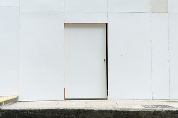 Obraz na płótnie Canvas sidewalk by street wall & door