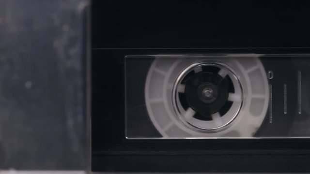 Retro double deck music cassette player detail playing tapes - camera slides between two tapes