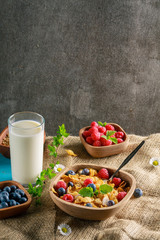 Cornflakes and other cereals with fresh fruits of raspberries, blueberries and milk on healthy breakfast.