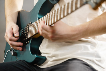 Fototapeta na wymiar Close up of man playing on electric guitar