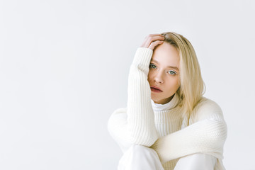 portrait of beautiful stylish blonde woman in white clothes looking at camera isolated on white
