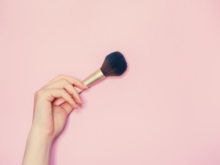 cosmetic and beauty concept from beauty asian hand hold and use cosmetic brush with isolated pink pastel background
