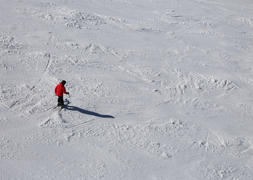 One skier in the slope with snow with red clothing
