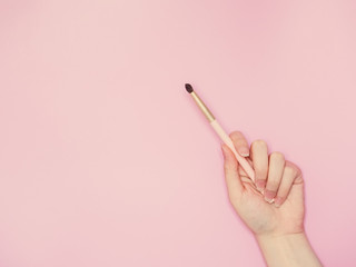 cosmetic and beauty concept from beauty asian hand hold and use cosmetic brush with isolated pink pastel background