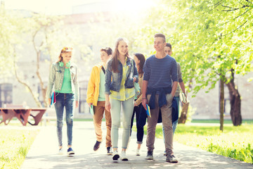 Obraz premium education, high school, communication and people concept - group of happy teenage students walking outdoors