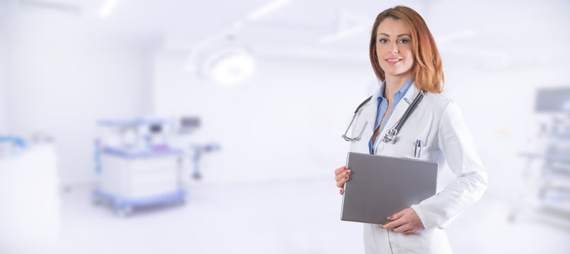 Portrait of a beautiful woman doctor with tablet over blue clinic interior