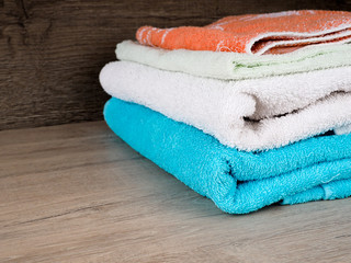 Stack of colorful bath towels. Pastel colors cotton towels. Hygiene, fabric, spa and textile concept